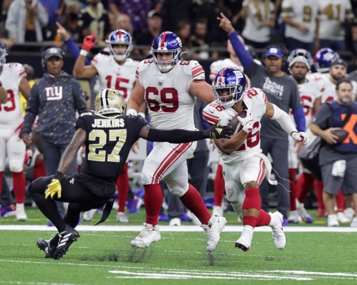 Oct 3, 2021; New York Giants running back Saquon Barkley (26) evades New Orleans Saints safety Malcolm Jenkins (27). Mandatory Credit: Stephen Lew-USA TODAY Sports